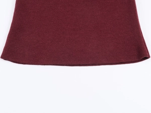 Vue détaillée de la texture en maille rouge foncé et de la finition soignée sur l'ourlet