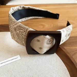Detail of paisley fabric headband featuring a brown square buckle and anti-slip lining