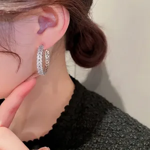 Silver leaf zircon hoop earrings with geometric C-shape design on female model