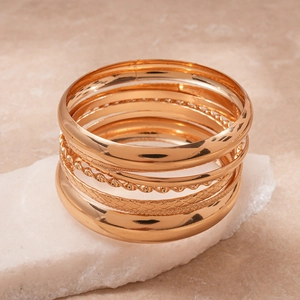 Detailed macro view of 8-piece gold geometric bracelets with varied textures and shiny finish