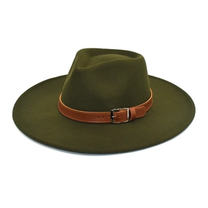 Détail d'un chapeau fedora vert olive avec une sangle en cuir brun et boucle argentée