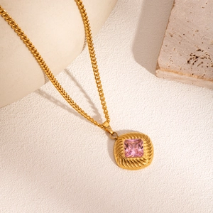 Nahaufnahme einer Vintage-Halskette mit rosa Edelstein und gravierter Relieftextur