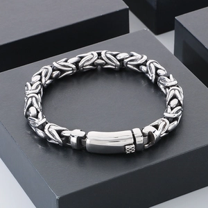 Detailed macro shot of silver braided stainless steel bracelet with sleek rectangular clasp