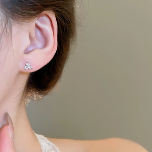 Close-up of elegant silver flower stud earrings with sparkling cubic zirconia on model
