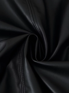 Gros plan sur la texture du cuir synthétique noir avec double couture fine sur une veste