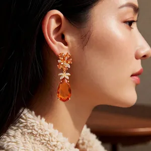 Vintage gold-plated earrings with orange pear-shaped zircon drops and floral crystal studs