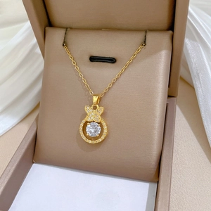 Close-up of a gold butterfly necklace with a sparkling round zircon in a velvet jewelry box