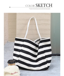 Detail of high-density striped canvas tote bag with white webbing handle for urban leisure