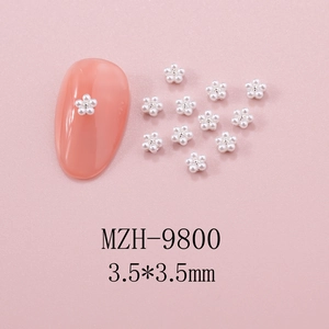 Close-up of 3.5mm pearl nail charms showing five-petal flower design on peach nail tips