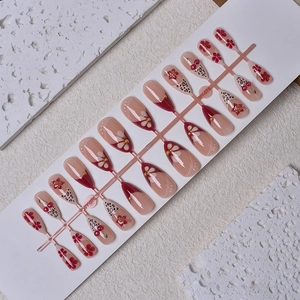 Long almond press-on nails with cherry designs, leopard print, and gold accents