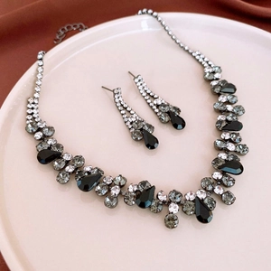 Macro shot of silver-tone teardrop pendant necklace and matching stud earrings