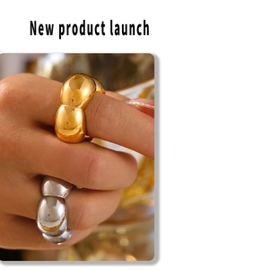 Close-up of wavy gold and silver high-polish thick rings on a model's hand