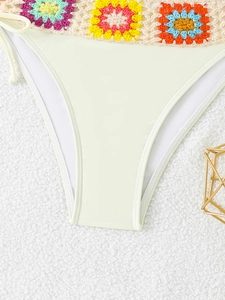 Detail of light beige bikini bottom with colorful handmade crochet floral waist and side ties