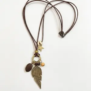 Vintage bohemian necklace with wooden beads and bronze leaf pendant on brown cord