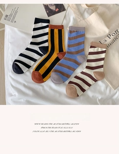 Detailed view of elastic ribbed cuffs on striped cotton socks in four classic colorways