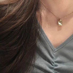 Elegante collana in acciaio inossidabile dorato con pendente quadrato su camicia blu