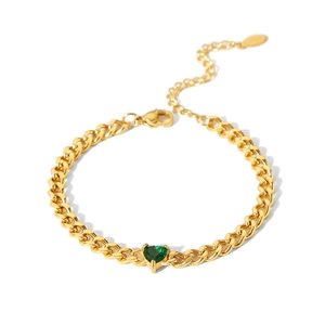 Gros plan sur un bracelet chaîne gourmette plaqué or 18 carats avec zircon cœur vert