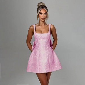 Détail du tissu jacquard rose et du grand nœud sur une robe moulante élégante