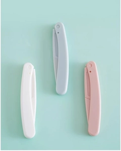 Detailed view of portable folding eyebrow razors in pastel pink, blue, and white colors