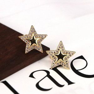 Detailed view of gold star stud earrings with micro-pave white zircon inlay and dual layers