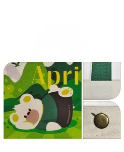 Detail view of the green cartoon bear print and reinforced stitching on canvas bag