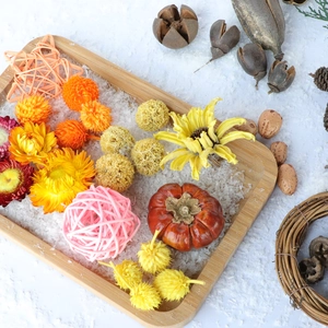 Dried flowers and pine cones arrangement in a wooden tray for autumn home decoration