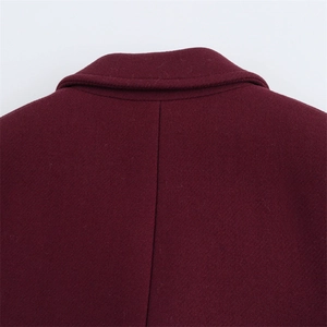 Dettaglio del cappotto di lana bordeaux che mostra il colletto e la trama del tessuto
