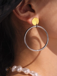 Macro de créoles bicolores en or 18 carats et argent portées par un mannequin de profil