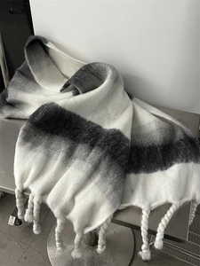 Detail of soft mohair-feel scarf featuring black and grey gradient with fringe tassels