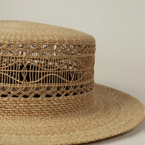 Nahaufnahme des Raffia-Flachhutes mit aufwendigem Hohlwebmuster und Handwerkskunst
