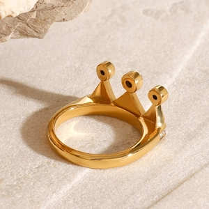 Bague couronne dorée élégante avec oxydes de zirconium sur fond de pierre