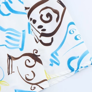 Close-up of white midi skirt fabric with abstract blue and brown line print