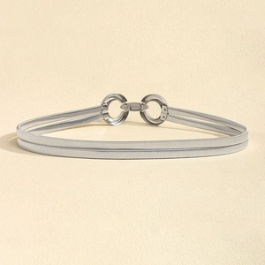 Detail of silver spring belt with round interlocking buckle on textured surface