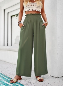 Détail d'un pantalon large vert à taille haute avec ceinture élastique froncée et poches
