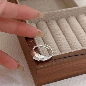 Close-up of a 925 silver croissant ring with pleated texture in a wooden jewelry box