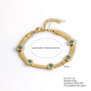 Macro detail of 18K gold plated stainless steel snake chain with blue rhinestones