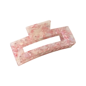 Pink marble acetate hair claw clip with rhinestones shown from a 45-degree angle