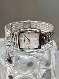 Detail view of square women watch with silver mesh band and white mother of pearl dial