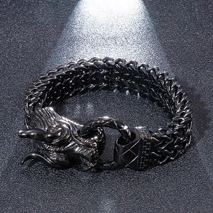 Macro detail of gunmetal dragon head clasp on a double-row punk style braided chain