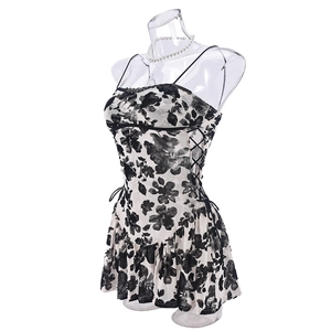Détail d'une robe fleurie avec lacets latéraux et ourlet à volants superposés