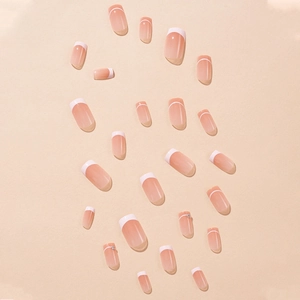Elegant white French tip press-on nails with rhinestone accents on a soft nude base