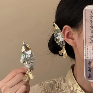 Dettaglio macro di un fermaglio per capelli a forma di pesce con finitura in madreperla