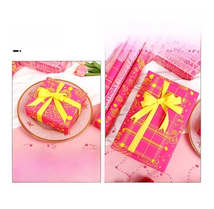 Macro shot of neon pink birthday wrapping paper with yellow cake prints and ribbons