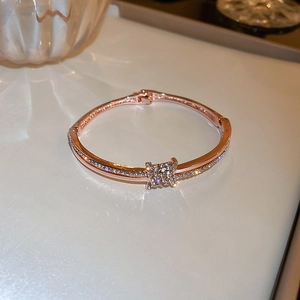 Detailed close-up of rose gold bangle featuring square pave setting with crystals