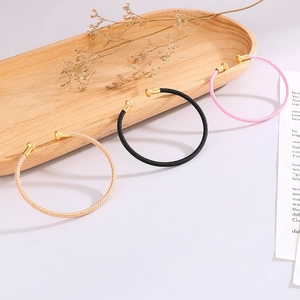 Three-piece set of C-shaped open bracelets with colorful woven leather and gold ball ends