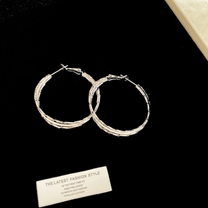 Detailed shot of large silver multi-layered hoop earrings with fine textured finish