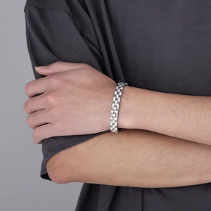 Détail d'un bracelet à maillons en acier inoxydable style huître porté sur le poignet