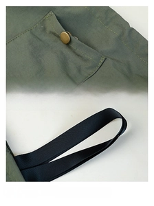 Detail of dark green lunch bag featuring durable metal snaps and reinforced woven handles
