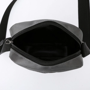 Overhead view of a grey Oxford fabric crossbody bag showing the inner storage space