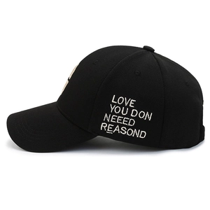 Black cotton baseball cap with white side embroidery text in 45-degree side view